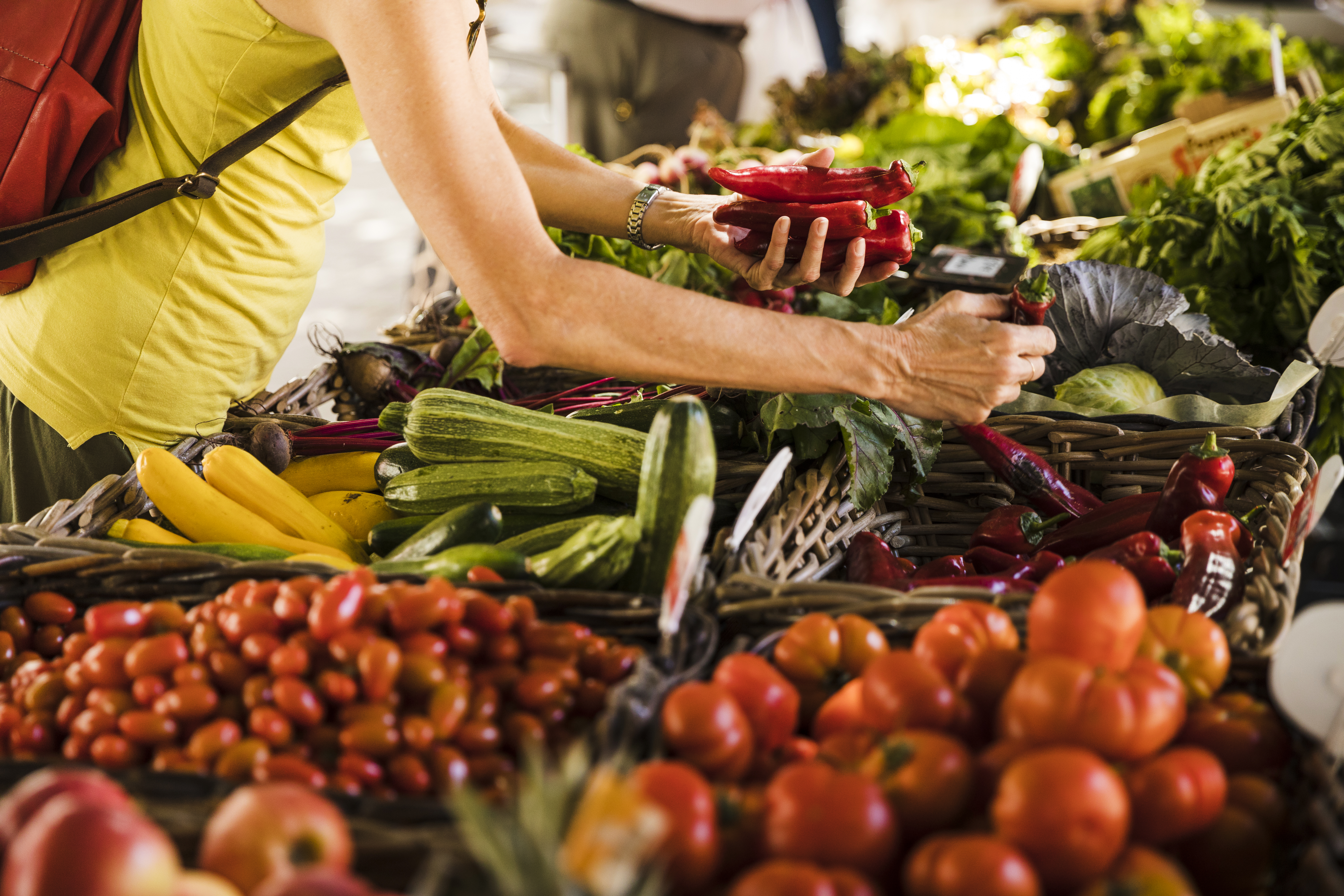 man-choosing-vegetable-from-vegetable-stall-supermarket